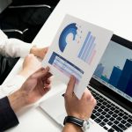 Home Business professionals discussing data charts and graphs in a modern office setting.