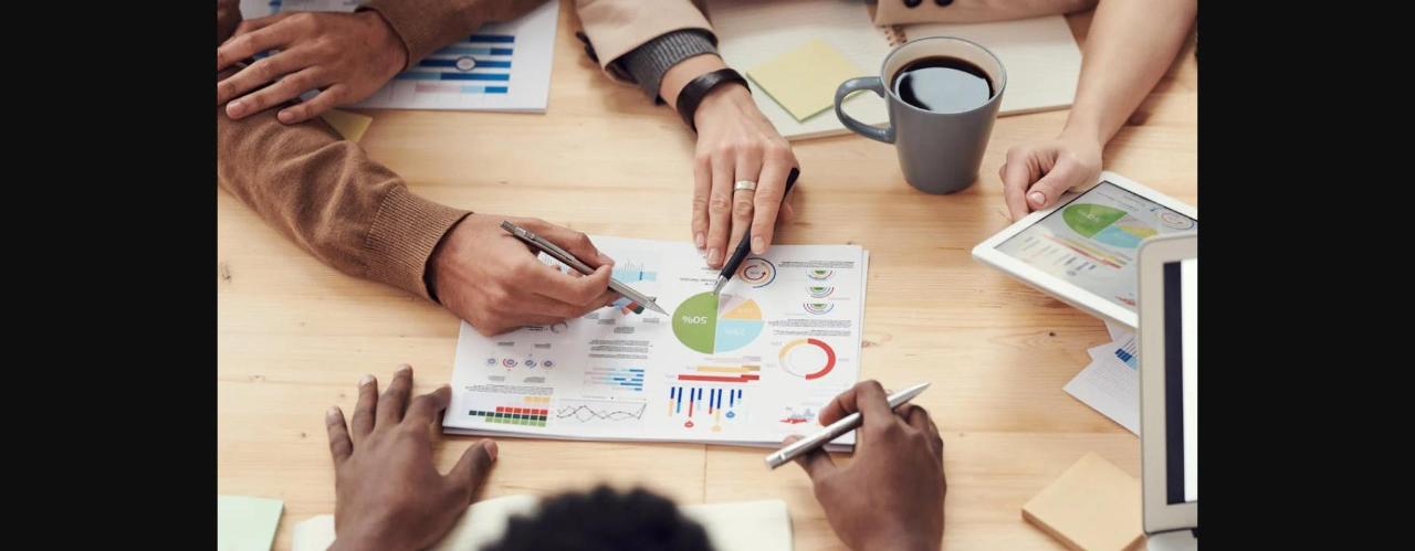 Business professionals discussing data charts and graphs in a modern office setting.